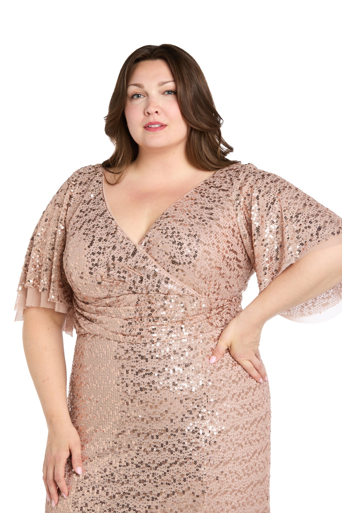 A woman models the R&M Richards 1011W Plus-Size Sequin Formal Dress in rose gold with short flutter sleeves against a white background.